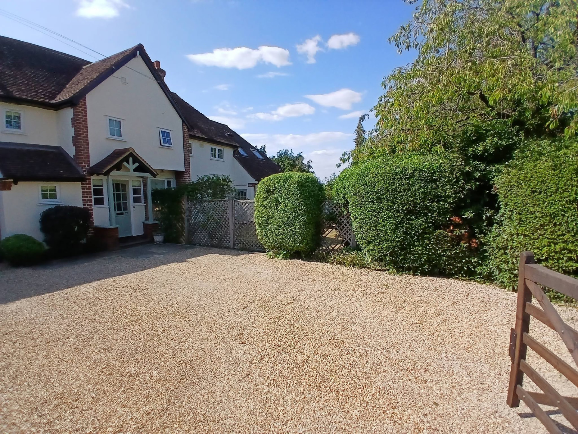 Neatly clipped round shrubs and hedges by a country home